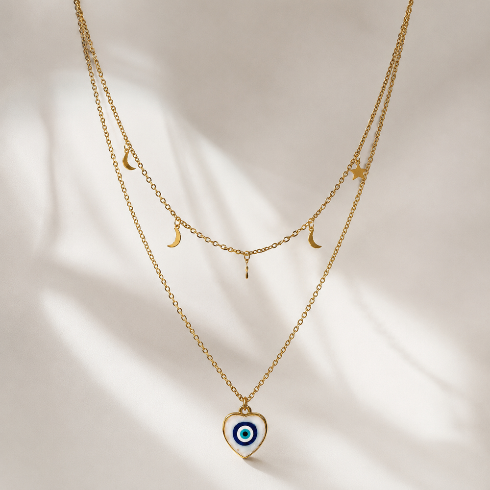 Gold layered NFC evil eye necklace with moon and star charms on white background